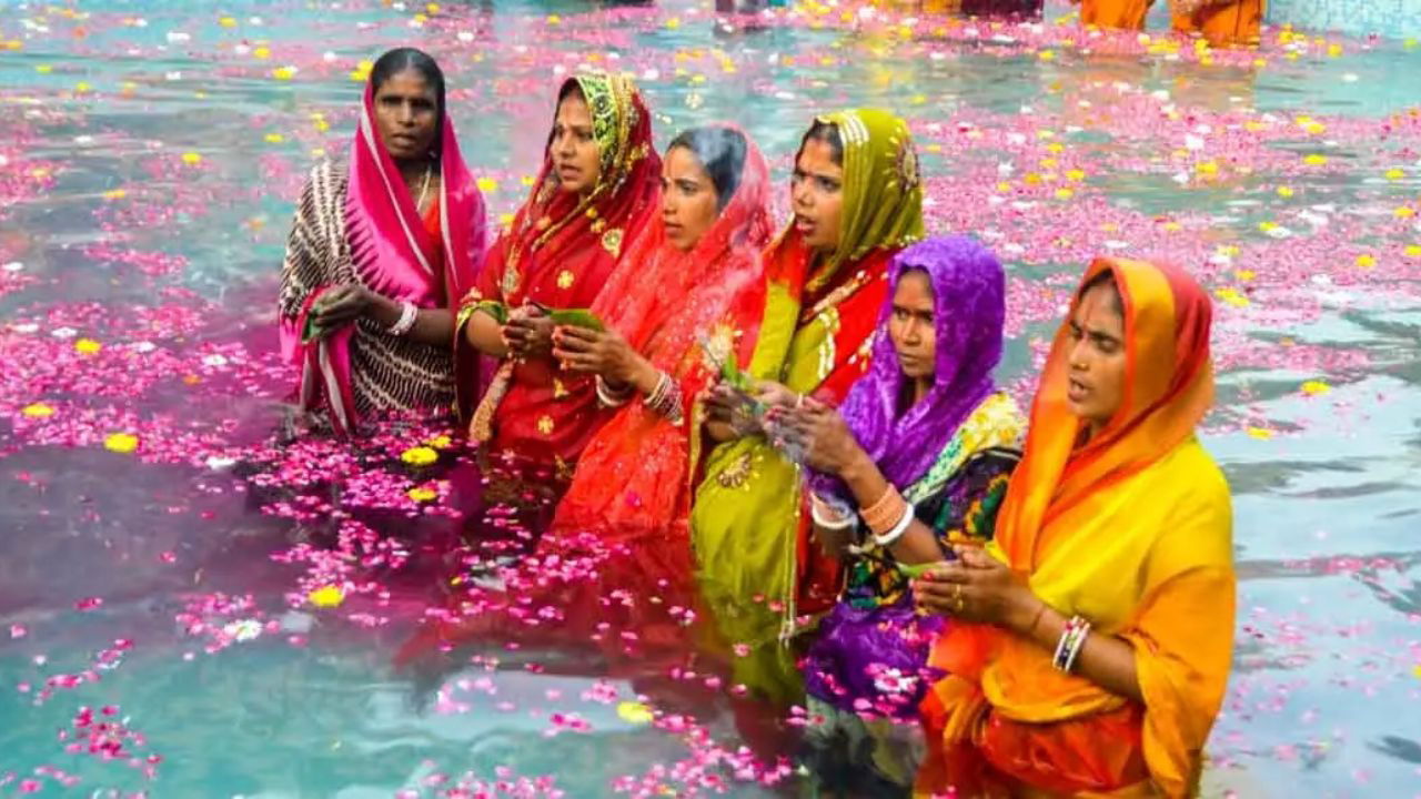 Women standing in water, thanking God Surya Dev for blessings such as prosperity, peace, and kindness during Chhath Puja