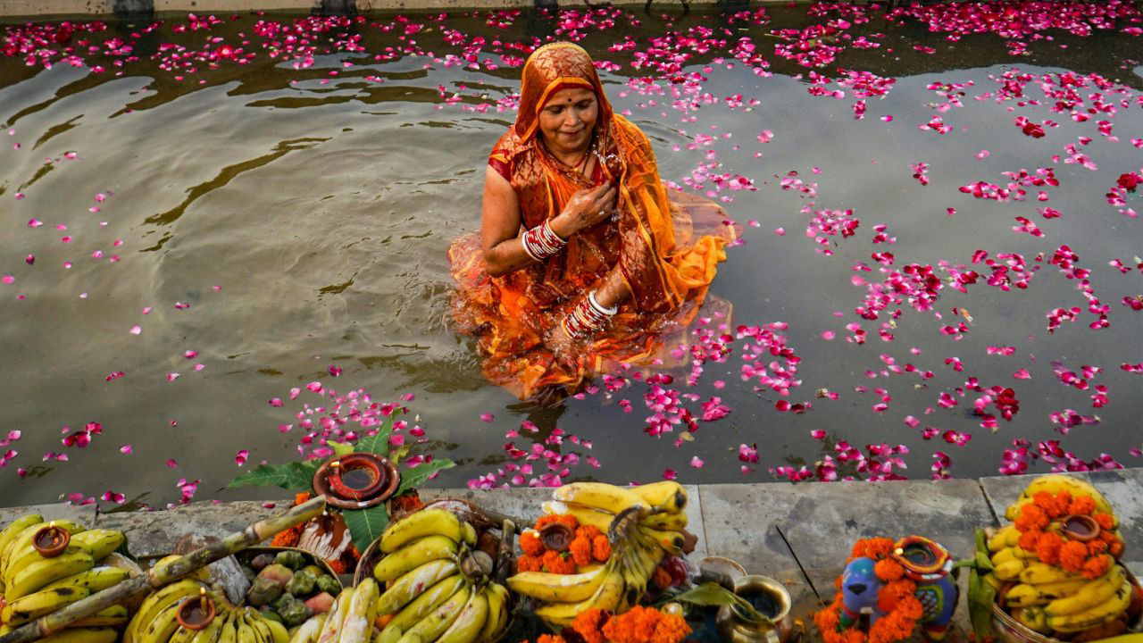 A woman worships Sun God as she celebrates Chhath Puja