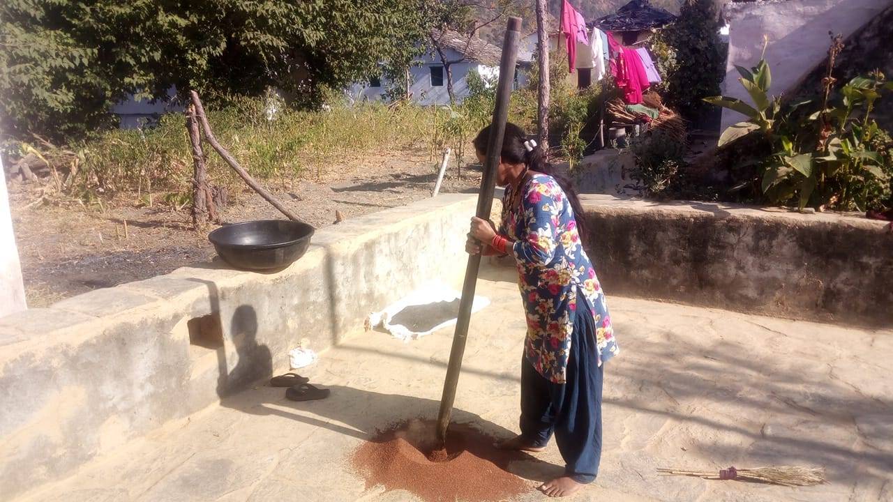 Woman farmer grinding the traditional way