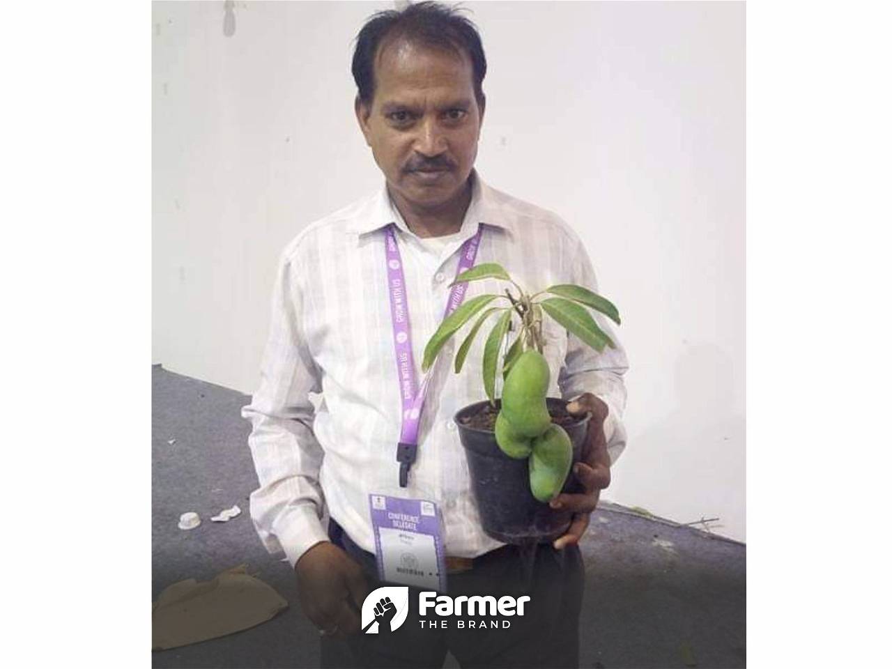 ShriKishan with a mango plant in a pot