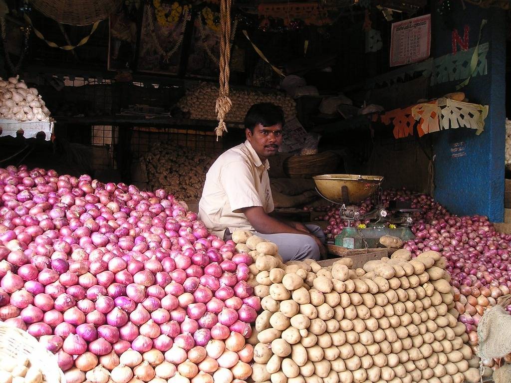 A trader with his onions and potatoes in a mandi