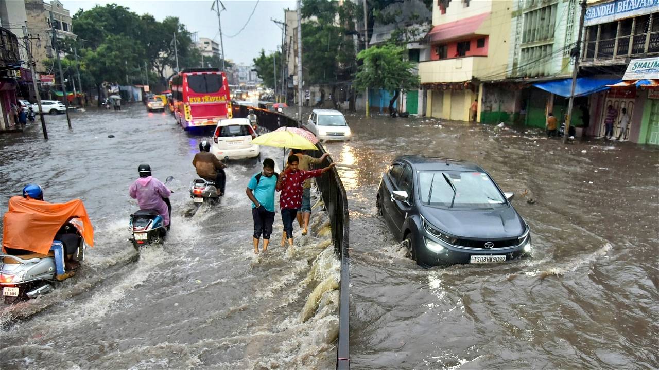Peope struggling to walk and travel on road filled with water