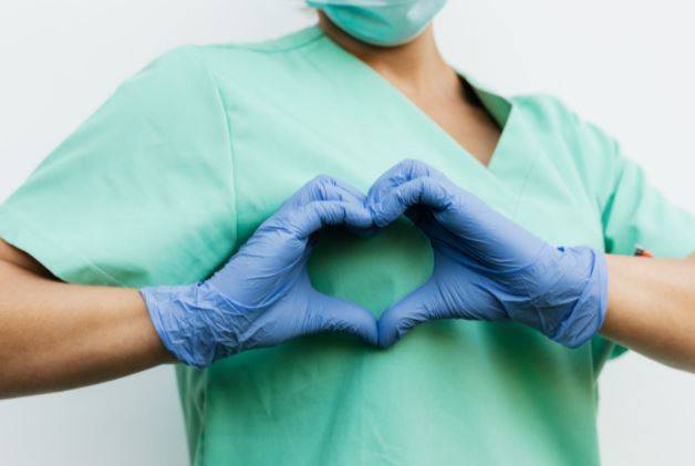 Female nurse showing heart sign