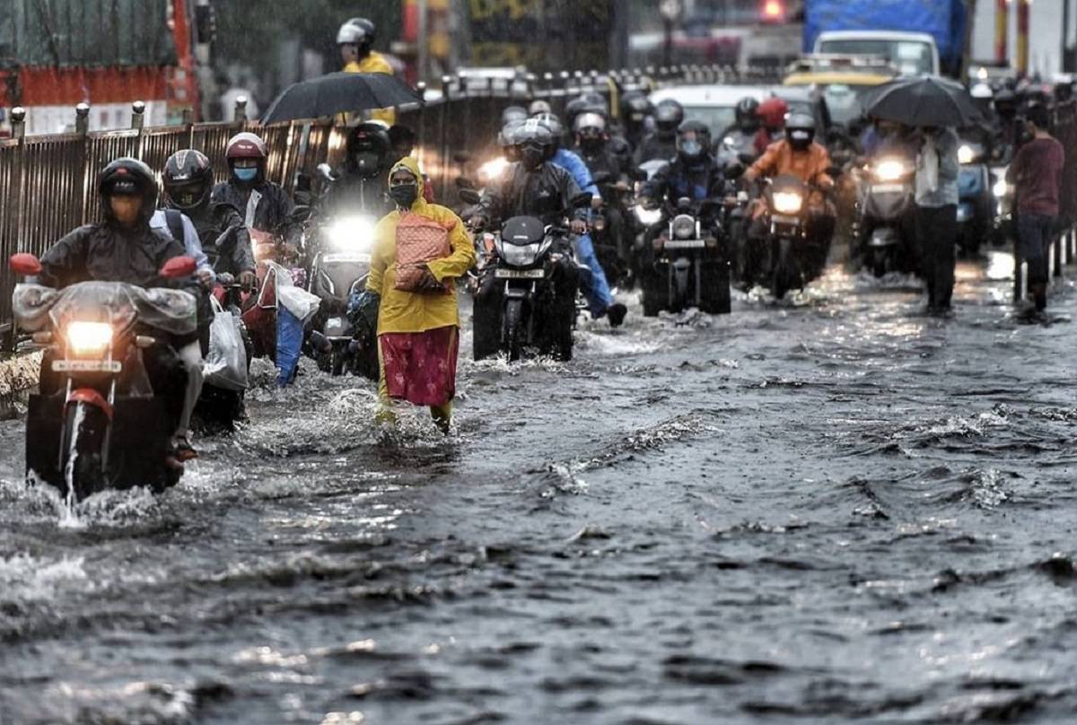 People driving motorcycle and walking in heavy rains