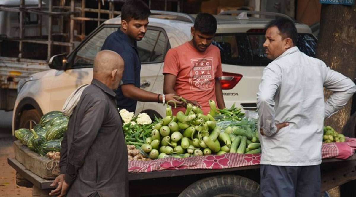 People buying vegetables from vegetable vendor