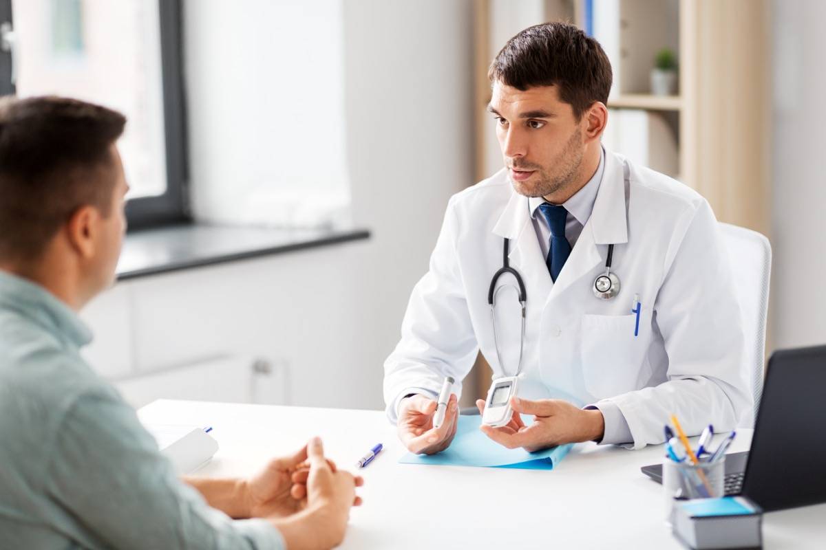 Doctor Demonstrating A Glucose Level Measuring Device