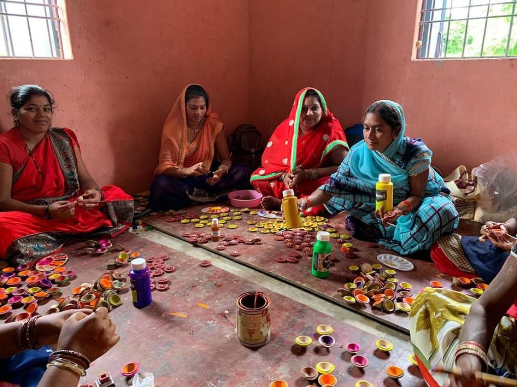 Women making diya of cow-dung