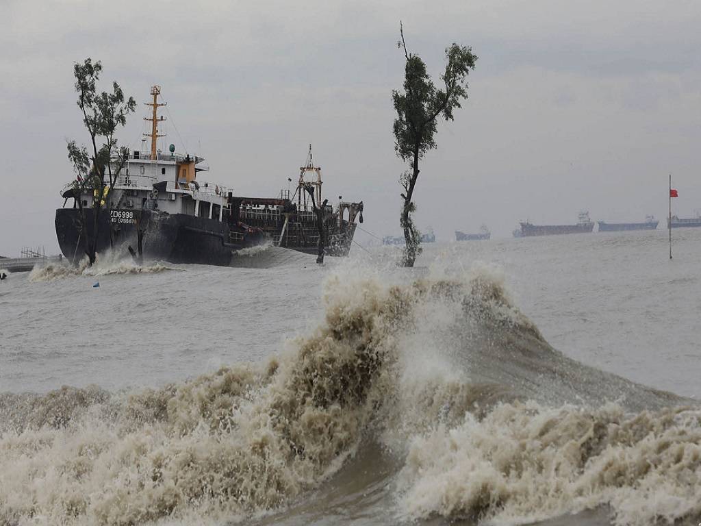 People wade through a flooded street amid continuous rain before the Cyclone Sitrang hits the country in Dhaka, Bangladesh, October 24, 2022.