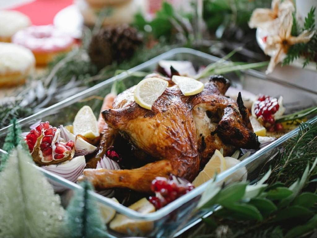 Traditional Christmas dinner features turkey with stuffing, mashed potatoes, gravy, cranberry sauce, and vegetables.