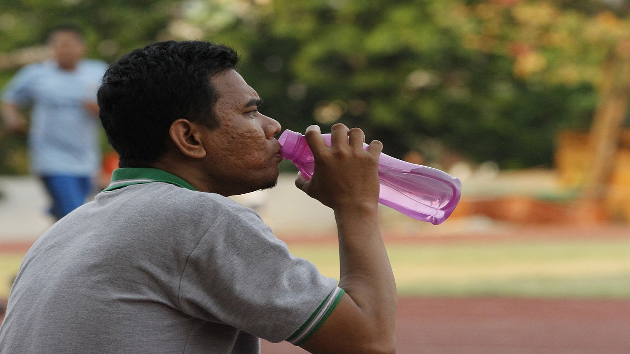 Man drinking water during summer to be hydrated (Photo Courtesy: Pixabay)