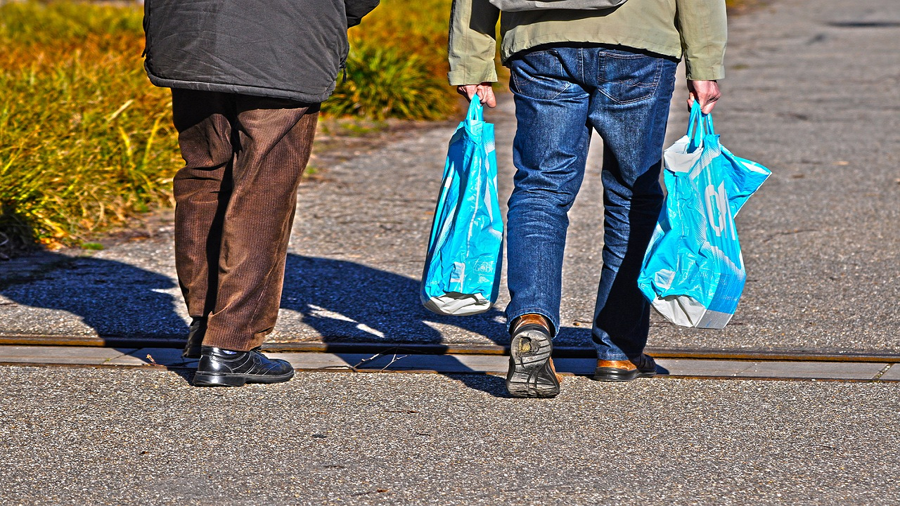 Men carrying plastic bags (Photo Courtesy: Unsplash)