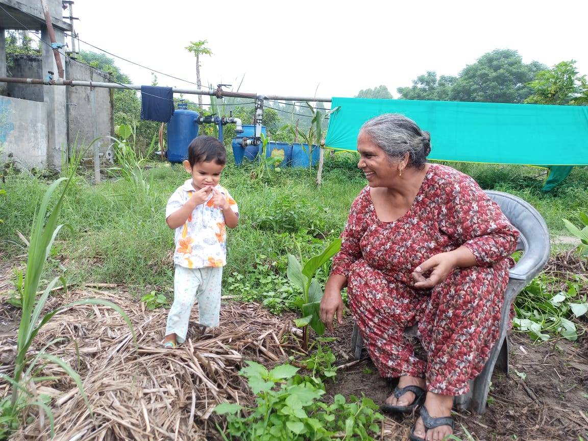 Manjit Kaur with her grandchild at her farm in Punjab